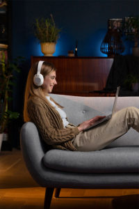 mujer con audifonos en laptop